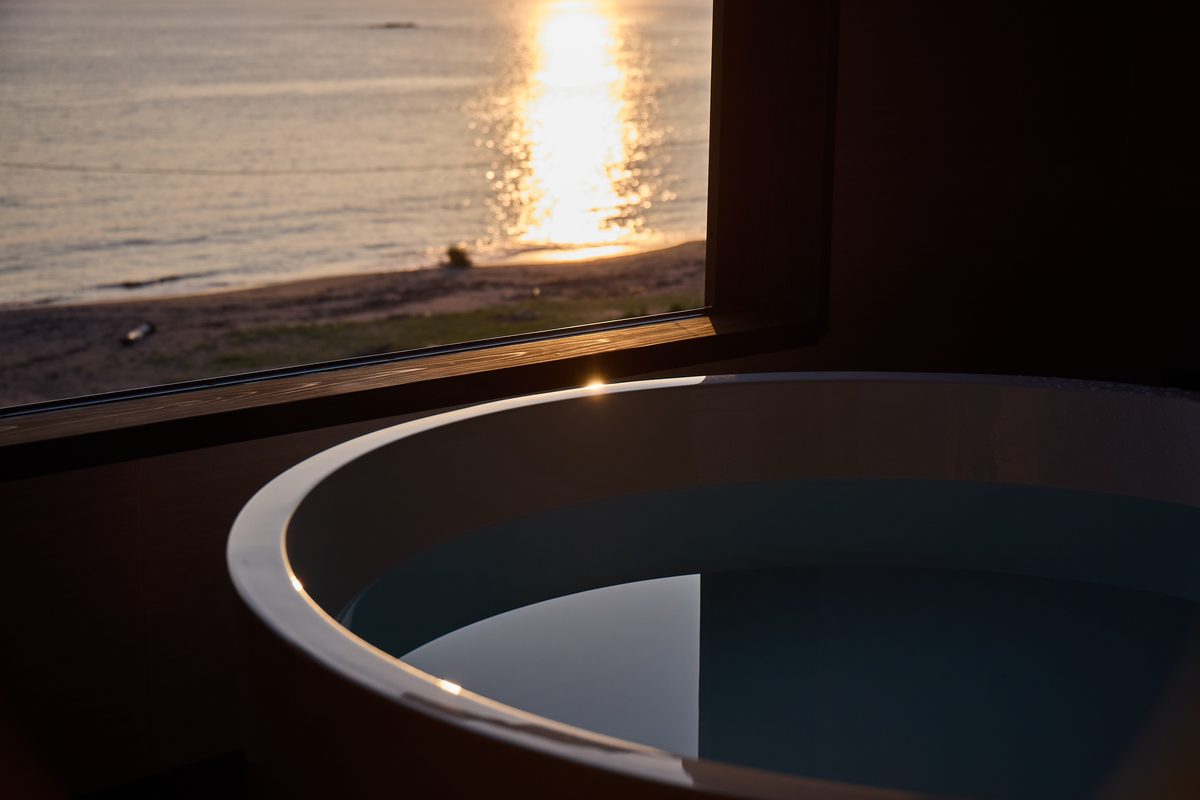 A guest room hot spring bath facing the sunset