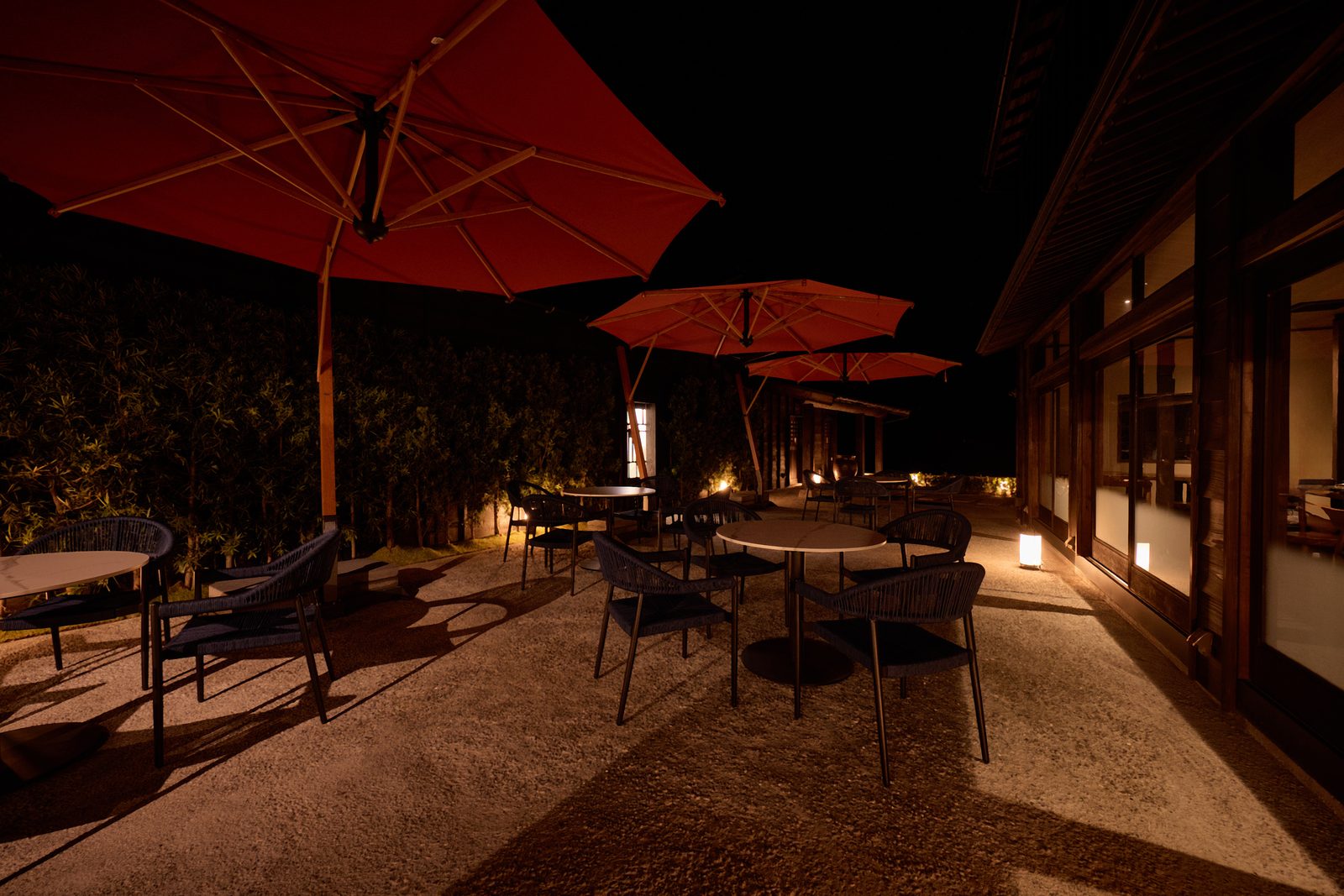 Red parasols lit up in the courtyard at night