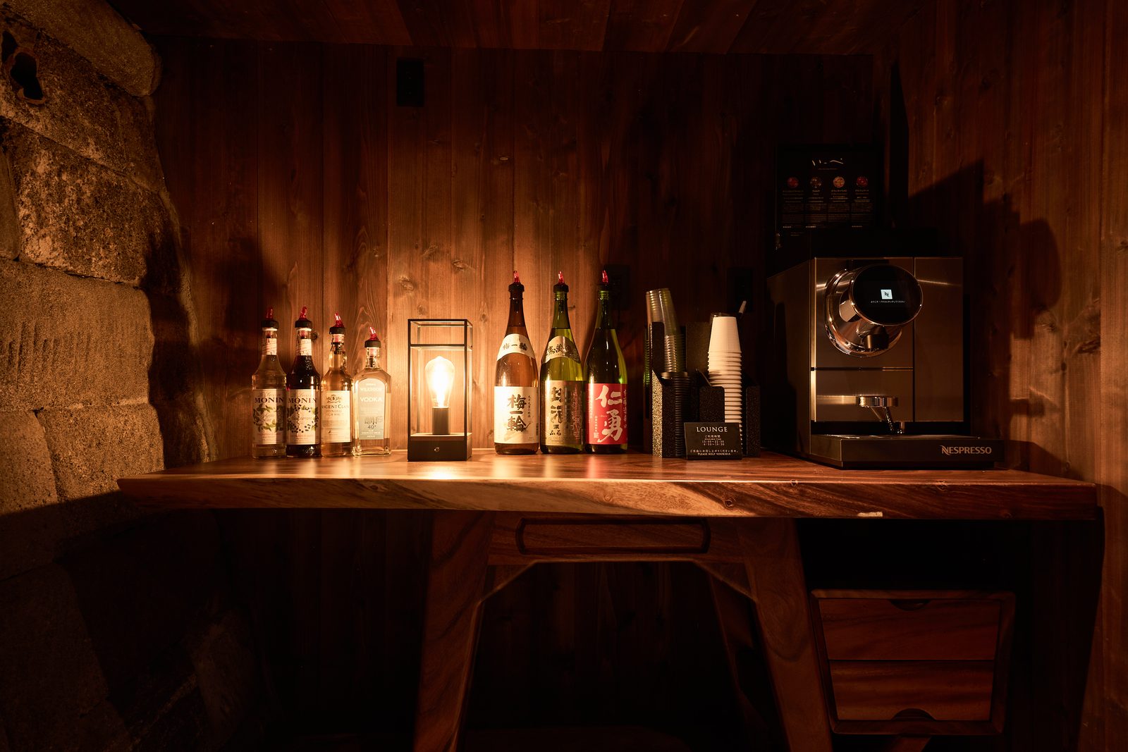 The lounge counter lined with local sake and a coffee machine